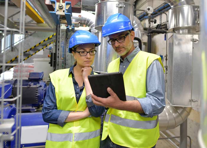 Factory workers checking list on clipboard